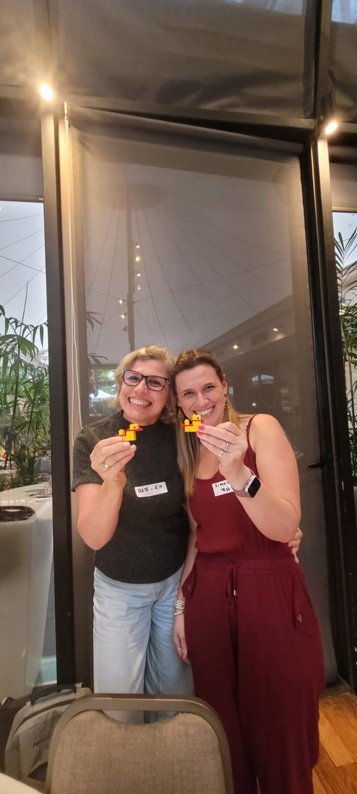 Two participants smiling with the ducks they built
